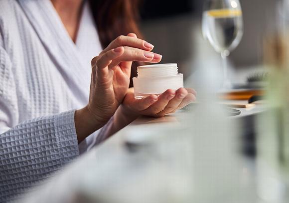 lady sitting at table with face cream