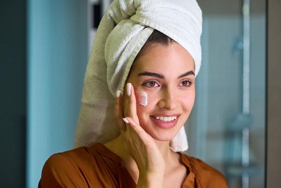 lady applying cream to face